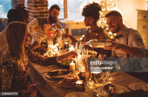 cozy new year dinner among friends - wine dinner stock pictures, royalty-free photos & images