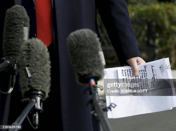 President Donald Trump reads from his notes as he talks to the media on the South Lawn of the White House before boarding Marine One in Washington,...