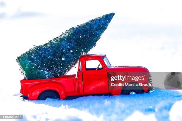 vintage red truck bringing the christmas tree home - christmas truck stock pictures, royalty-free photos & images