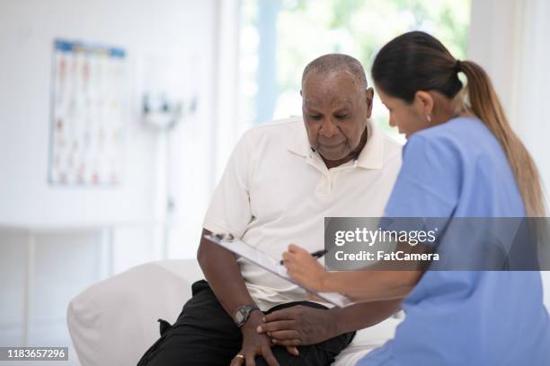 ein älterer herr in seinem arztbüro erhält ein check-up-stockfoto - gerontology stock-fotos und bilder