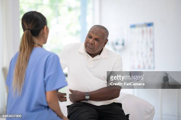 an elderly gentleman in his doctors office receiving a check-up stock photo - fat hips stock pictures, royalty-free photos & images