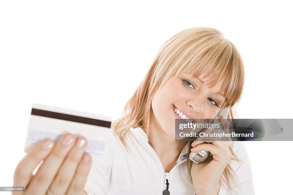 Smiling  woman talking on the phone with her credit card