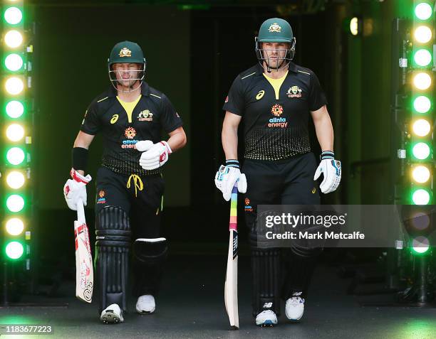 David Warner and Aaron Finch of Australia walk out to bat during the Twenty20 International match between Australia and Sri Lanka at Adelaide Oval on...