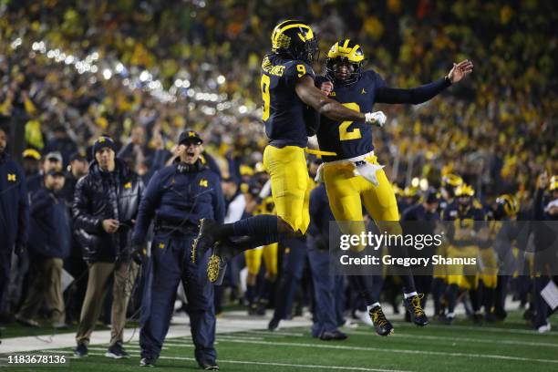 Donovan Peoples-Jones of the Michigan Wolverines celebrates his second half touchdown catch with Shea Patterson in front of head coach Jim Harbaugh...