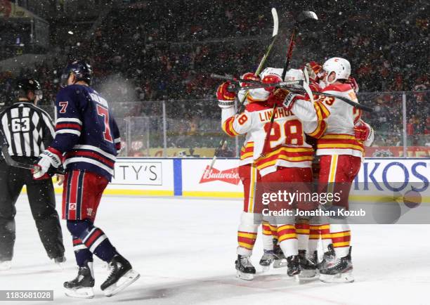 Elias Lindholm, Sean Monahan, Mark Giordano, Matthew Tkachuk and Johnny Gaudreau of the Calgary Flames celebrate Lindholm's goal as Dmitry Kulikov of...