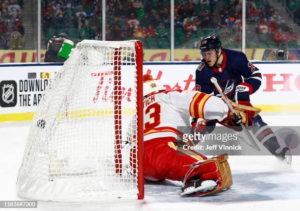 Bryan Little of the Winnipeg Jets scores the game-winning goal against goaltender David Rittich of the Calgary Flames in overtime during the 2019 Tim...