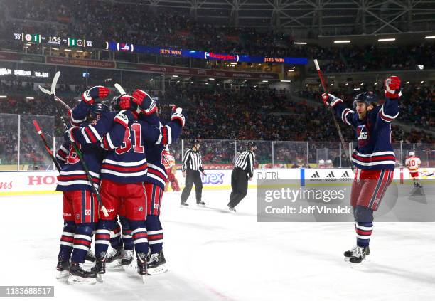 Bryan Little of the Winnipeg Jets celebrates with his teammates after scoring the game-winning goal in overtime during the 2019 Tim Hortons NHL...