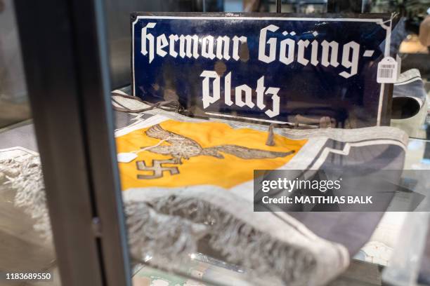An enamel plate reading "Hermann Goering-Platz" square and a kettledrum decoration with a swastika are pictured on November 20, 2019 at the «Hermann...