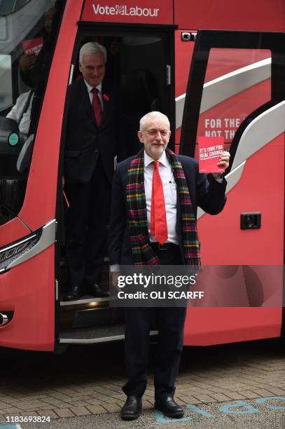 Britain's Labour Party leader Jeremy Corbyn holds up a copy of their general election manifesto as he arrives with Labour Party Shadow Chancellor of...