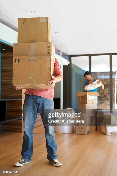 man carrying boxes - pile of clothes stock-fotos und bilder