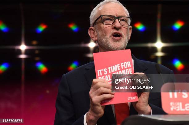 Britain's opposition Labour Party leader Jeremy Corbyn holds aloft a copy of the party's manifesto, as he speaks during the launch of the Labour...