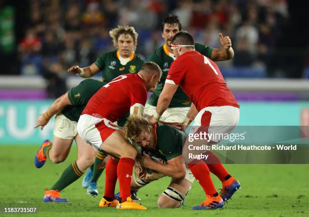 Pieter-Steph du Toit of South Africa is tackled by Hadleigh Parkes and Wyn Jones of Wales during the Rugby World Cup 2019 Semi-Final match between...