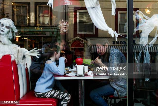 Family sit and have breakfast in a cafe decorated with Halloween ghosts during Whitby Goth Weekend on October 27, 2019 in Whitby, England. The Whitby...