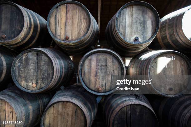 stack of port wine barrel in a wine cellar - whiskey stock pictures, royalty-free photos & images