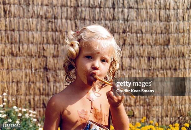 little girl eating chocolate pudding, portrait - vanillesoße stock-fotos und bilder
