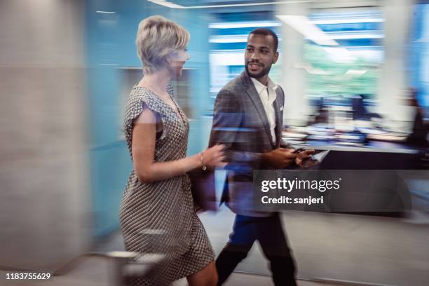business people walking across the corridor, blurred motion - businesswear stock pictures, royalty-free photos & images