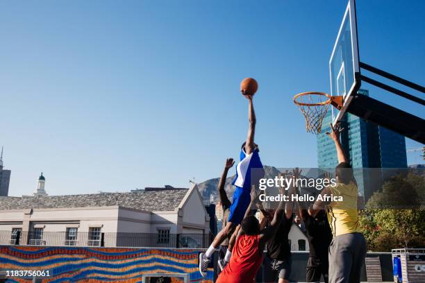 tall player floating in to score a basket - competition round photos et images de collection