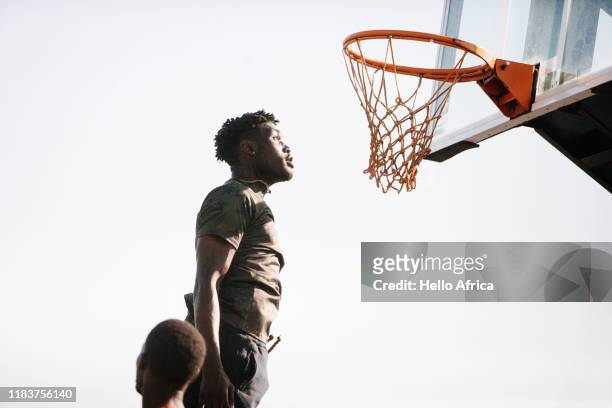 Fit basketball player jumping very high to look at the hoop