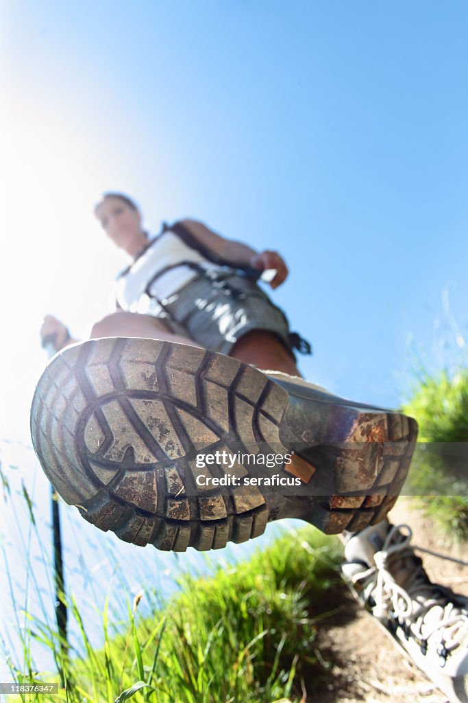 Sole of hikers sneaker as he is walking down the trail