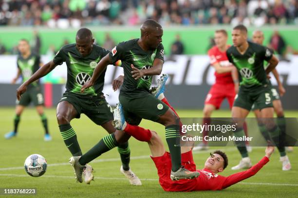 Jerome Roussillon and Josuha Guilavogui of Wolfsburg battle for the ball with Ruben Vargas of Augsburg during the Bundesliga match between VfL...