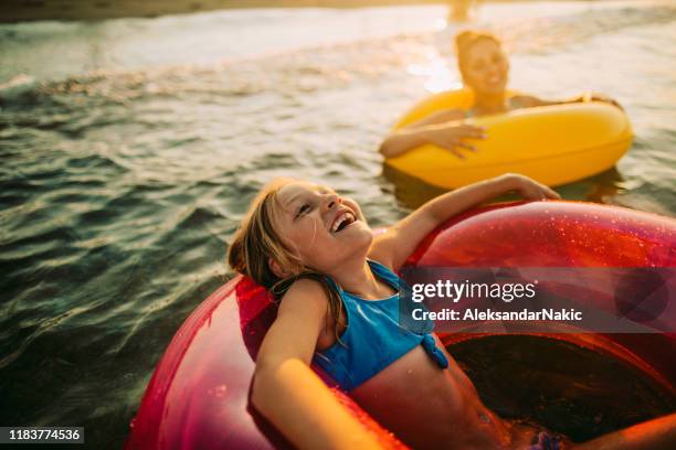 aktivitäten am meer - schwimmring stock-fotos und bilder