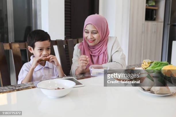 a boy having a breakfast prepared by his grandmother - sandwich generation stock pictures, royalty-free photos & images