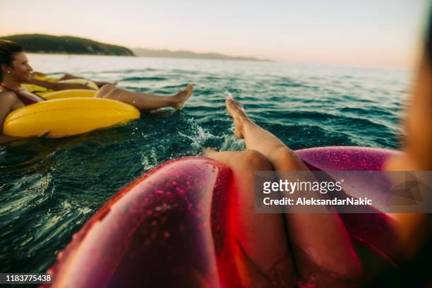 ontspannen op opblaasbare ringen - droplet sea summer stockfoto's en -beelden