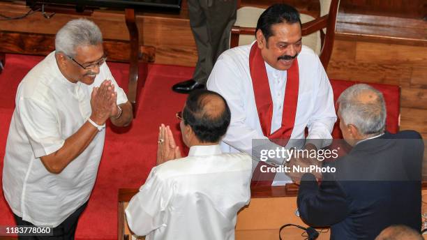 Sri Lankan President Gotabaya Rajapaksa and new Prime Minister, his brother, former president Mahinda Rajapaksa, , greet the outgoing former Sri...