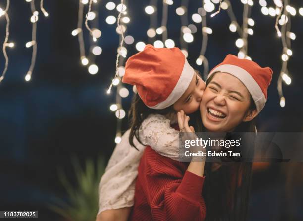 una femmina cinese asiatica che porta sua sorella dal retro durante la celebrazione della cena della vigilia di natale - kiss sisters foto e immagini stock