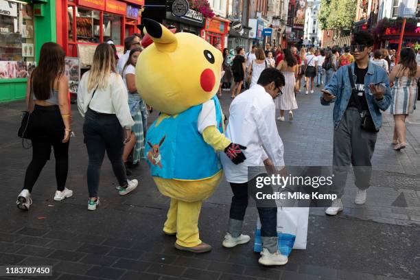 Tourists in Chinatown have their photo taken with a Pokemon Pikachu character in London, England, United Kingdom. The present Chinatown is in the...