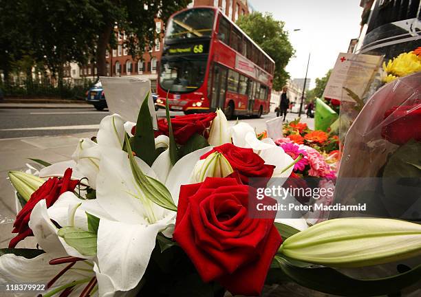 Bus passes floral tributes placed next to a memorial remembering the victims of the London bus bombing 7/7 terrorist attacks on July 7, 2011 in...