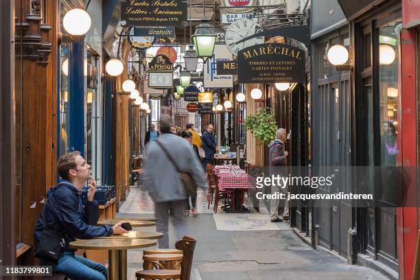 shops in a passage couvert (shopping corridor or gallery) in paris, france - arcade stock pictures, royalty-free photos & images
