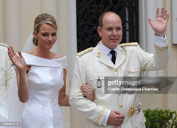 Princess Charlene of Monaco and Prince Albert II of Monaco wave to the crowds as they leave Sainte Devote church after the religious ceremony of...