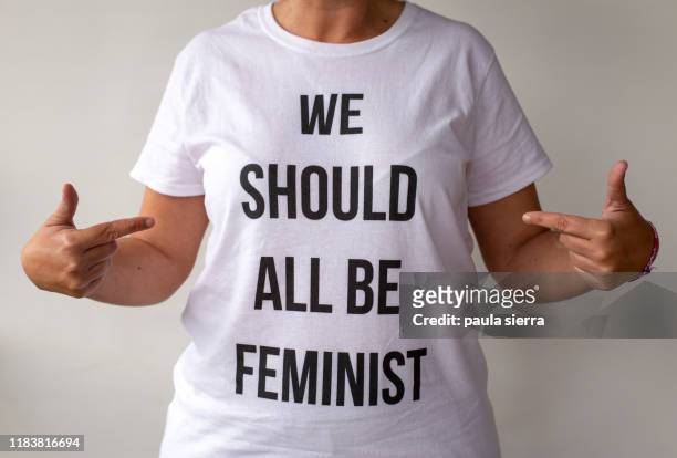woman wearing a feminist tshirt: 'we should all be feminist' - all shirts stock-fotos und bilder