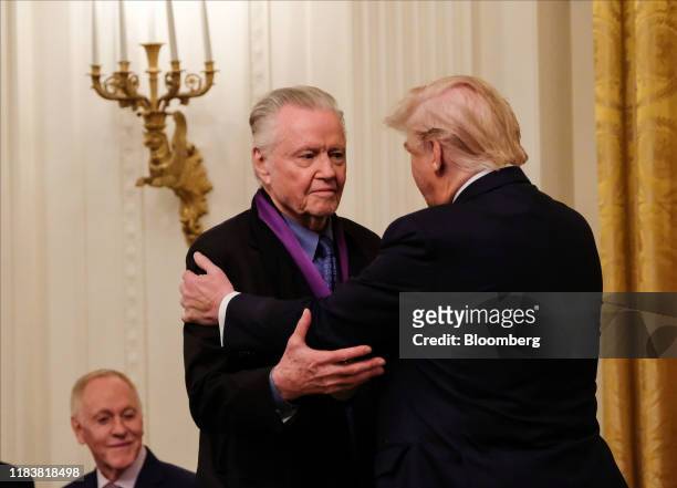 President Donald Trump, right, embraces actor Jon Voight after presenting him the National Medal of Arts in the East Room of the White House in...