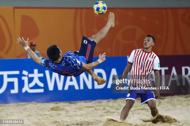 Takuya Akaguma of Japan plays an overhead kick against Edgar Barreto of Paraguay during the FIFA Beach Soccer World Cup Paraguay 2019 group A match...