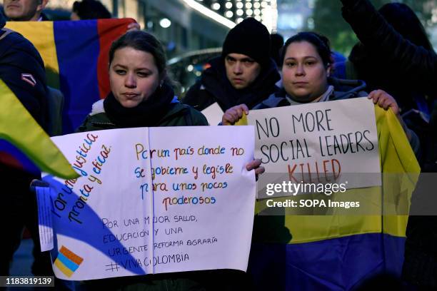 Protesters are seen holding placards. People gathered outside the Colombian embassy in the UK to stand in solidarity with the General Strike in their...