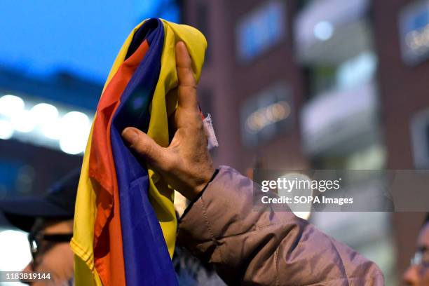 Protester holds a Colombian flag during the protest.. People gathered outside the Colombian embassy in the UK to stand in solidarity with the General...