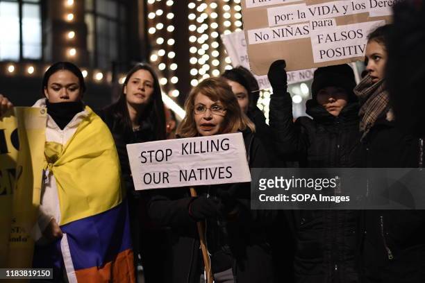 Protester holds a placard that says Stop killing our natives during the demonstration. People gathered outside the Colombian embassy in the UK to...