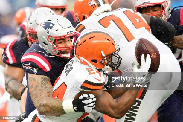 Running back Nick Chubb of the Cleveland Browns fumbles as he is hit by defensive tackle Lawrence Guy of the New England Patriots in the first...