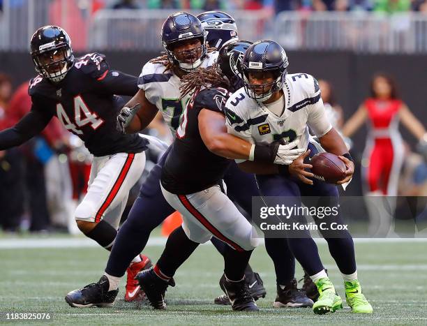 Russell Wilson of the Seattle Seahawks is sacked by Tyeler Davison of the Atlanta Falcons in the second half at Mercedes-Benz Stadium on October 27,...