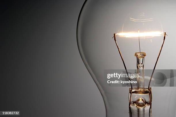 close-up shot of illuminated light bulb with copy space - idea studio shot stockfoto's en -beelden