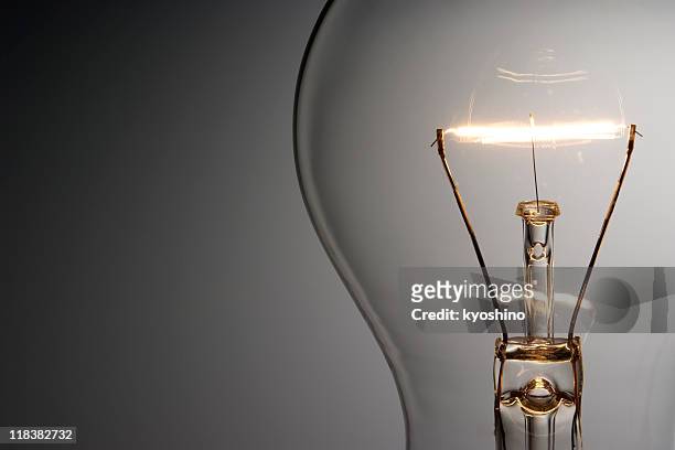 close-up shot of illuminated light bulb with copy space - light bulb stock pictures, royalty-free photos & images