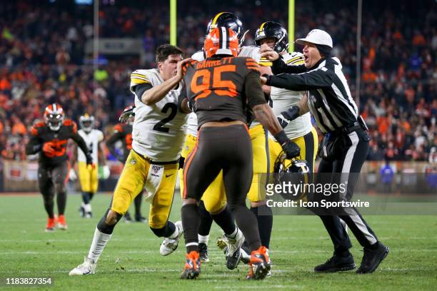 Cleveland Browns defensive end Myles Garrett prepares to strike Pittsburgh Steelers quarterback Mason Rudolph in the head with his own helmet as...
