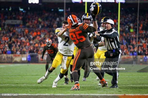 Cleveland Browns defensive end Myles Garrett prepares to strike Pittsburgh Steelers quarterback Mason Rudolph in the head with his own helmet as...