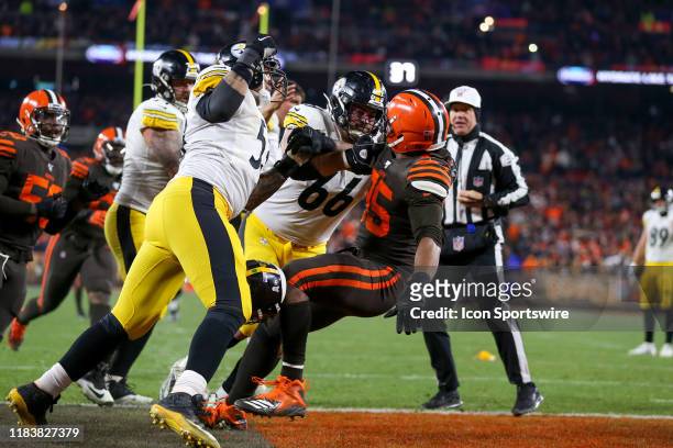 Pittsburgh Steelers center Maurkice Pouncey and Pittsburgh Steelers offensive guard David DeCastro subdue Cleveland Browns defensive end Myles...