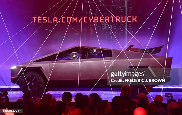 People take pictures of the newly unveiled all-electric battery-powered Tesla's Cybertruck with shattered windows after a failed resistance test, at...