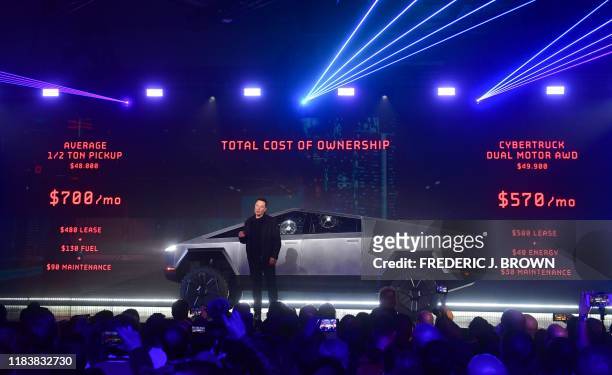 Tesla co-founder and CEO Elon Musk speaks in front of the newly unveiled all-electric battery-powered Tesla's Cybertruck with shattered windows,...