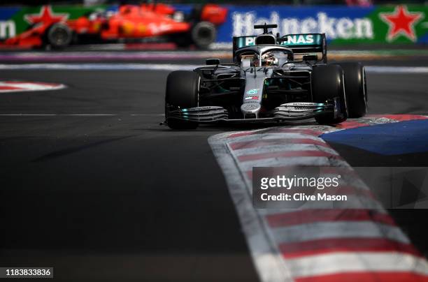 Lewis Hamilton of Great Britain driving the Mercedes AMG Petronas F1 Team Mercedes W10 leads Sebastian Vettel of Germany driving the Scuderia Ferrari...