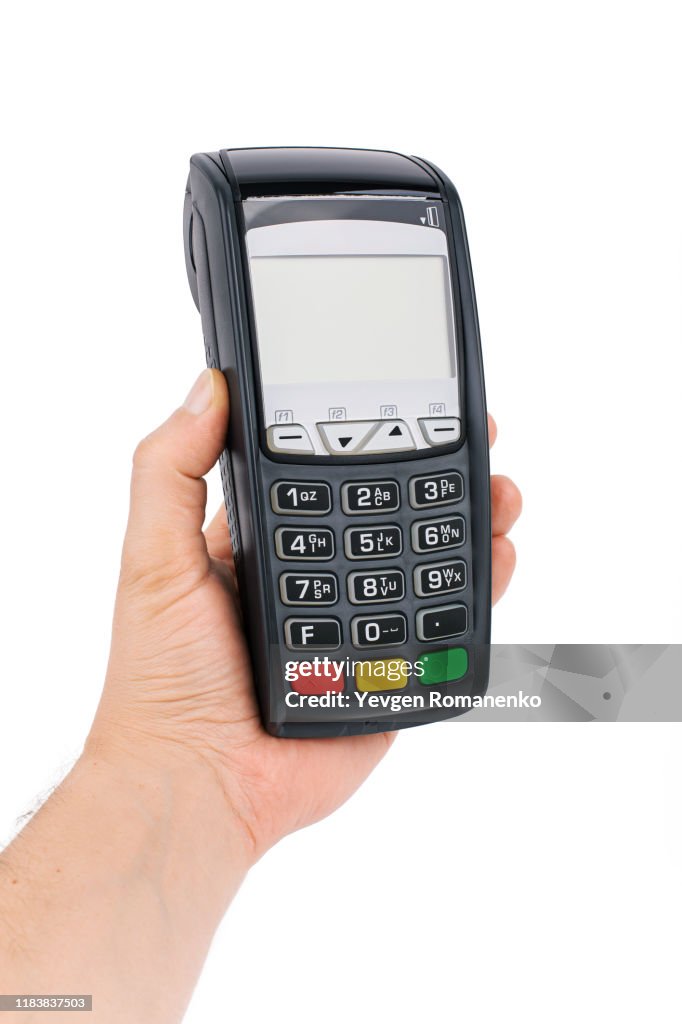 Credit card terminal in hand isolated on white background. Close up of POS terminal in hand